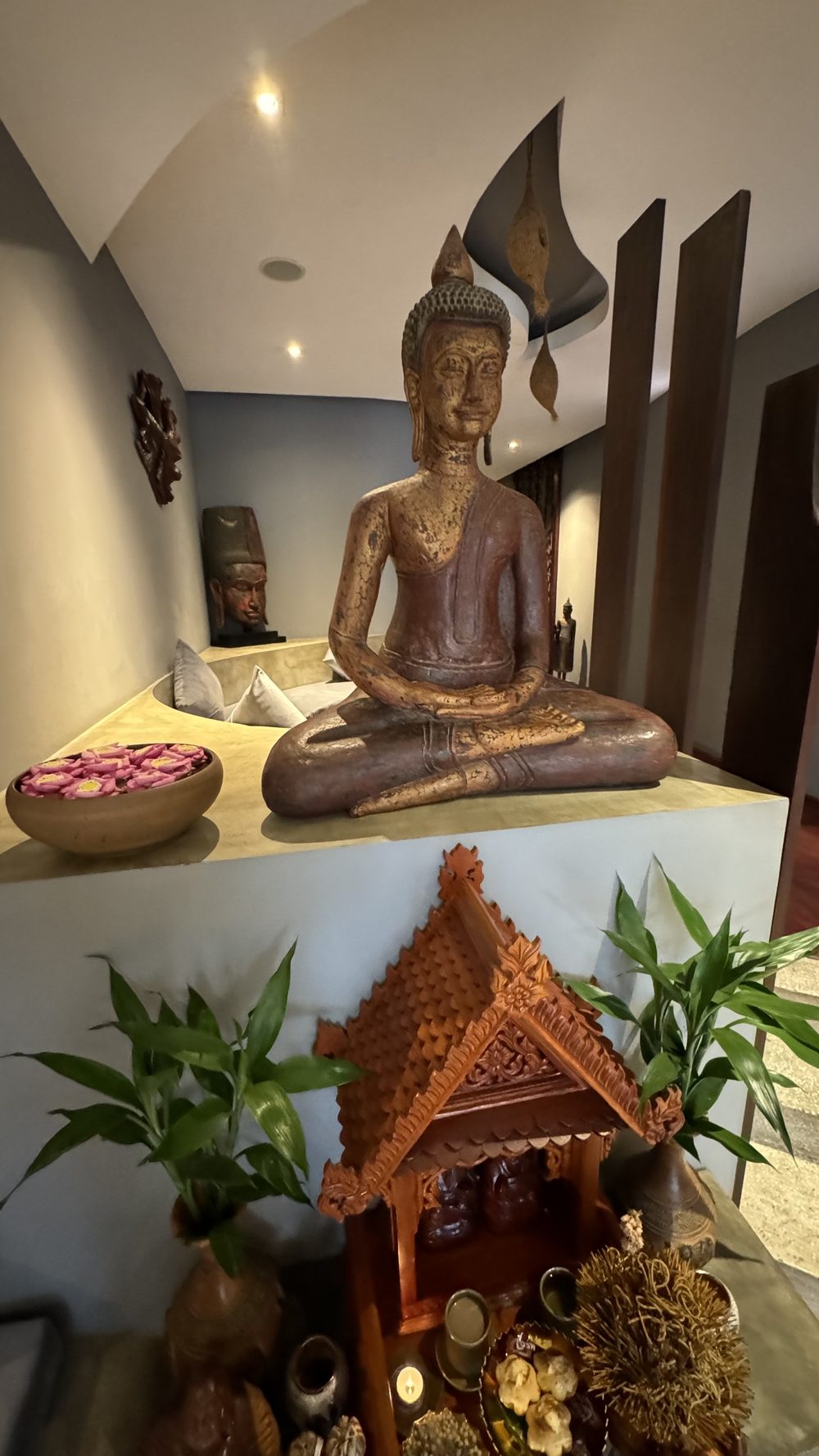 Spa reception interior with a Buddha statue and floral offering bowl