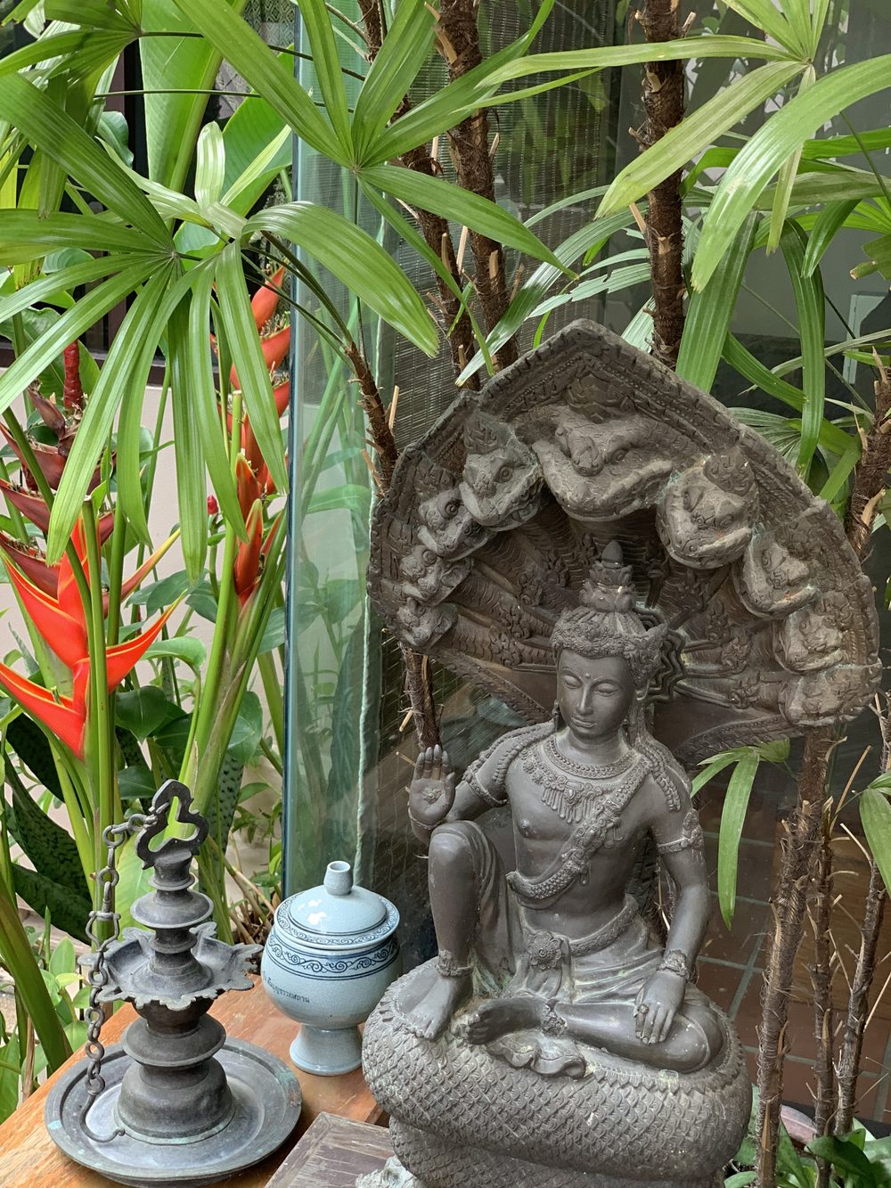 Small Buddha statue among plants and decorative vessels in a spa garden
